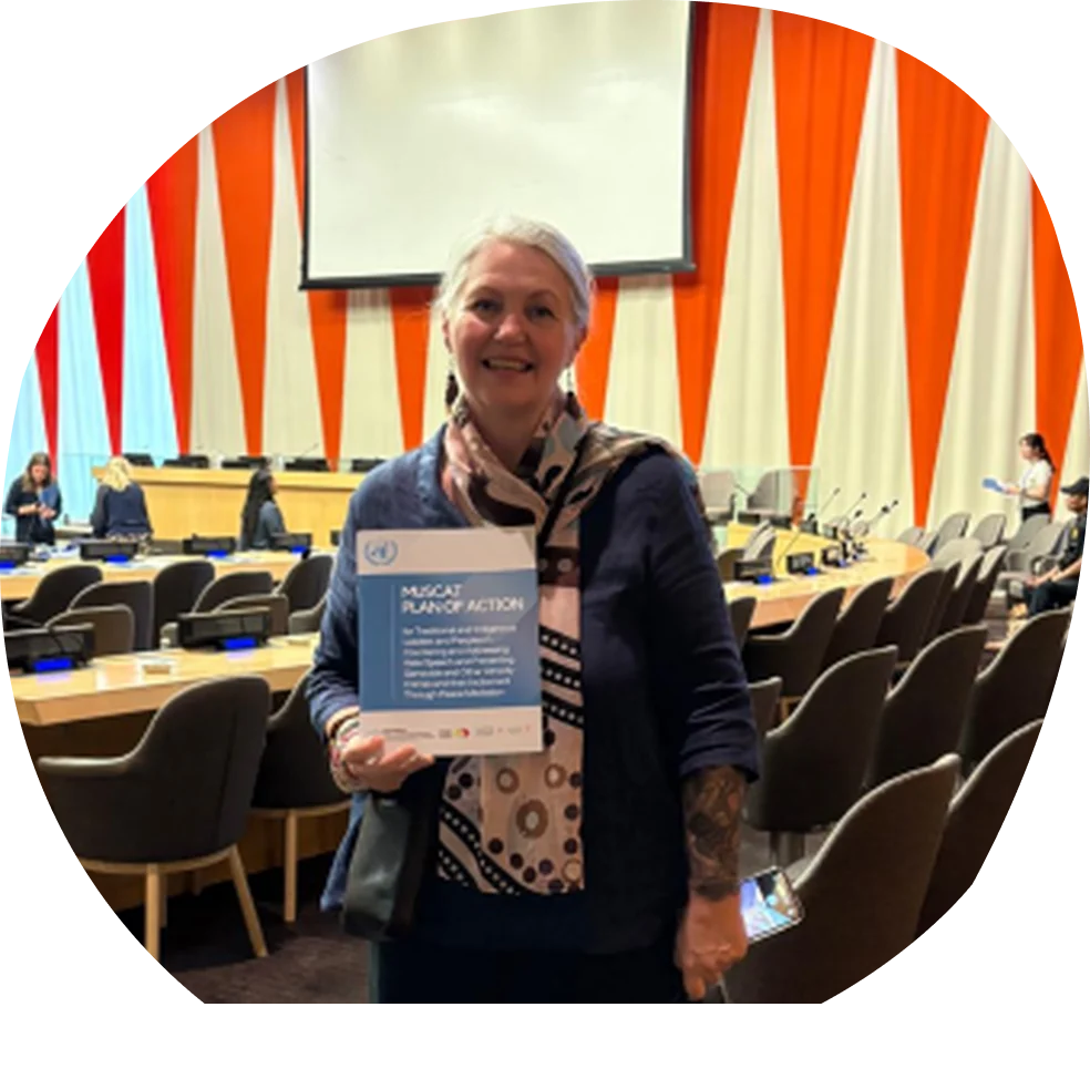 A woman holding the Muscat Plan of Action in a United Nations conference room.
